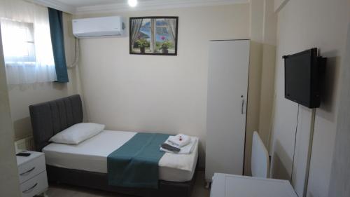 a small room with a bed and a tv at Odak Pansiyon in Canakkale