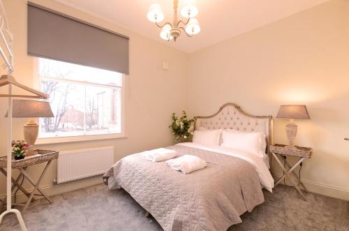 a bedroom with a bed with two lamps and a window at The Glossop Suite in Sheffield