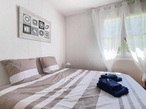 une chambre avec un lit avec deux sacs dessus dans l'établissement La Grimaudière, calme, campagne, animaux acceptés, à Saint-Étienne-de-Crossey