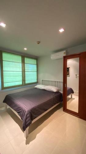 a bedroom with a bed and a large mirror at Seaview Condominium A13 in Ban Tha Fat