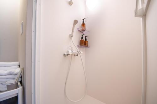 a bathroom with a shower with a shower head at LOCO Minamiichi in Nara
