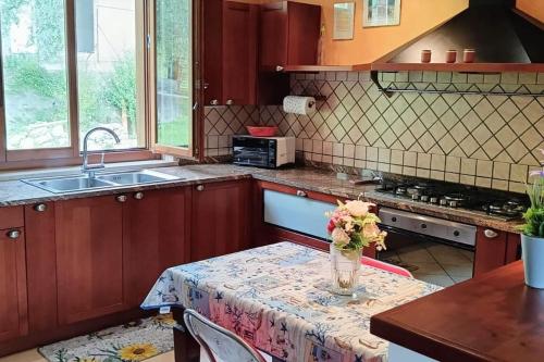 a kitchen with a table with a vase of flowers on it at Lago di Sole X 6 Point Break in Marone
