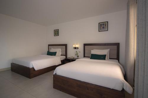 two beds in a hotel room with two beds sidx sidx sidx at Vrest Hotel in Phnom Penh