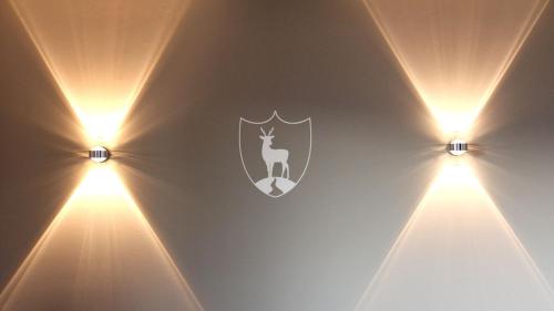 a room with two lights on a wall with a shield at Design Suite Maximilian Tegernsee - Das Alpbach in Tegernsee