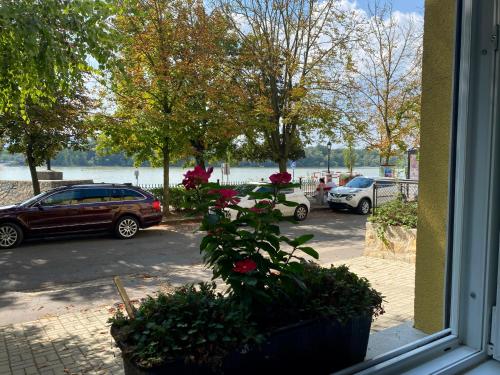 a window with a view of a parking lot with cars at Bellevue Vendégház 2 in Vác