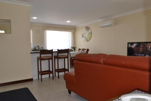 a living room and kitchen with a couch and a table at Dolphin Lodge Albany - Self Contained Apartments at Middleton Beach in Albany