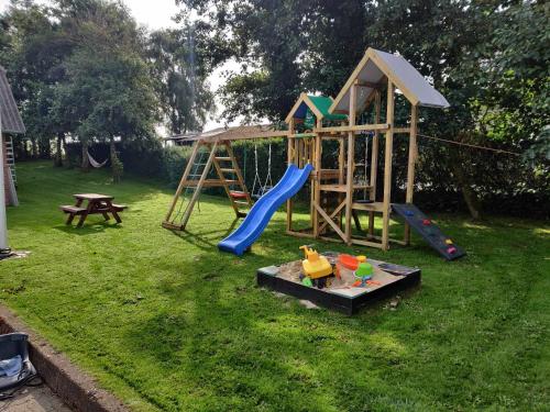 a playground with a slide and a swing set at Stort og dejligt værelse med privat bad in Hornsyld