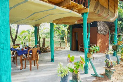 a patio with a table and chairs under awning at Rana Treehouse in Piduragala