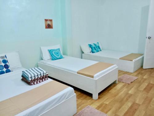 a room with two beds and a couch at Pearls Z Apartelle in Boracay