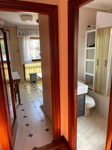 a bathroom with a toilet and a sink and a mirror at Aires de Playa in Arija
