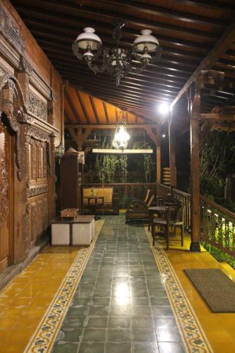 a living room with a table and chairs and a ceiling at Cokro Hinggil - Traditional View in Sleman