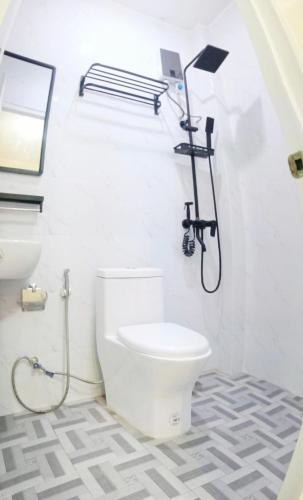a bathroom with a toilet and a shower at Wyne's Tiny House near Royal Farm Resort in Dipolog