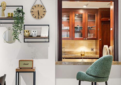 Una habitación con una silla y un reloj en la pared. en 5 Min Walk to Burj Khalifa 2BHK Luxury Downtown Burj Haven, en Dubái