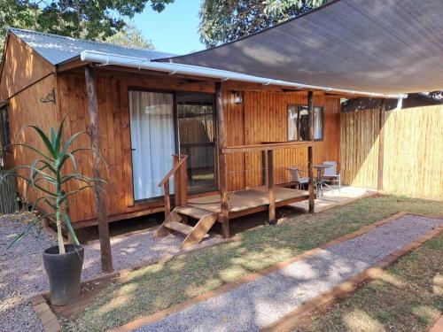 a wooden cabin with a porch and a table at SOH Simple Accommodation in Kloof