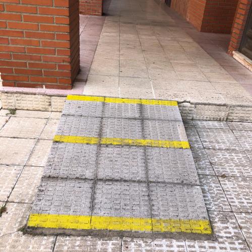 a sidewalk with a yellow and gray grate on the ground at Piso céntrico y luminoso in León