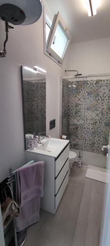 a bathroom with a sink and a toilet and a mirror at Donna Beatrice aMare beach house in Donnalucata