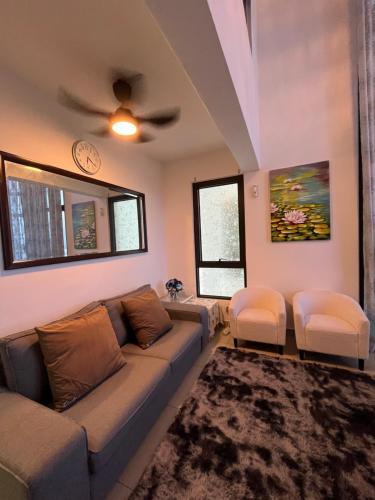 a living room with a couch and two chairs at Duplex 3R2B Eclipse Residence in Cyberjaya