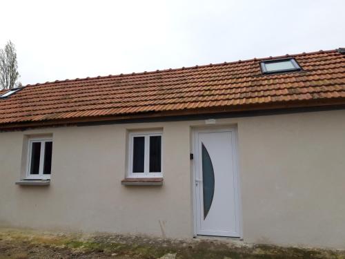a white house with a brown roof at Apartement à Theuville-Baigneaux in Theuville