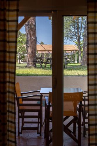 a view of a table and chairs through a window at Elenas Beach Studios in Vourvourou