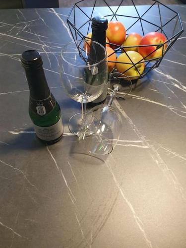 two bottles of wine and a basket of fruit on a counter at Eigentumswohnung in Dresden in Dresden