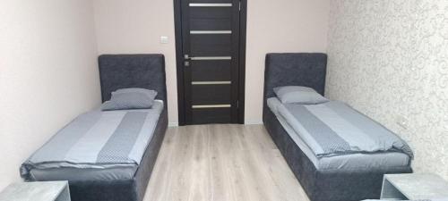 two beds in a small room with a door at HotelRoom 21 in Uzhhorod