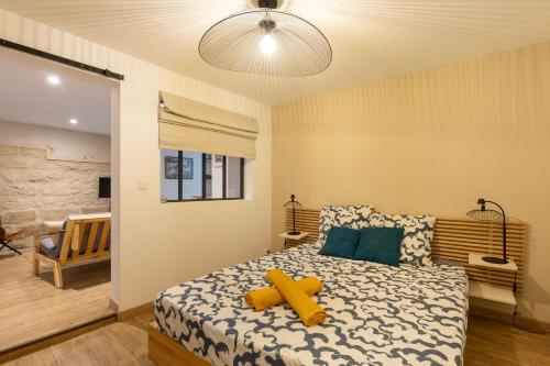 une chambre avec un lit avec un ours en peluche dessus dans l'établissement Le Reflet du Rhône - Intramuros - Wifi - Clim, à Avignon