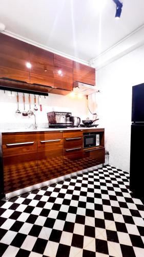 a kitchen with a black and white checkered floor at uouRangnamHouse in Bangkok