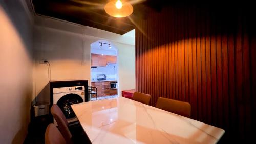 cocina con mesa blanca y pared roja en uouRangnamHouse, en Bangkok
