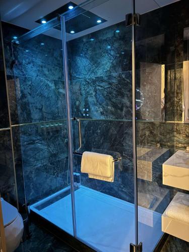 une salle de bain avec une douche avec une porte vitrée dans l'établissement Lueur de miel, à Bonneuil-sur-Marne