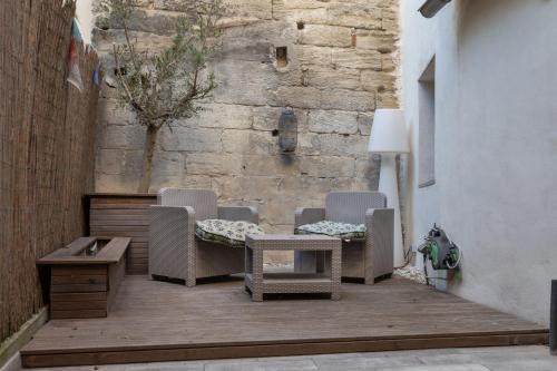 un groupe de chaises et une table sur une terrasse en bois dans l'établissement Le Reflet du Rhône - Intramuros - Wifi - Clim, à Avignon