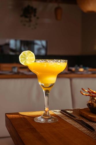 a drink in a glass with a lime on a table at Samawa Living in Paje
