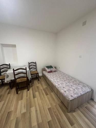 a bedroom with two beds and a table and chairs at gvero apartment’s in Prilep