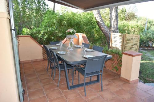 une table noire et des chaises sur une terrasse dans l'établissement Maison de 4 chambres de front de mer Corse-du-Sud, à Appietto