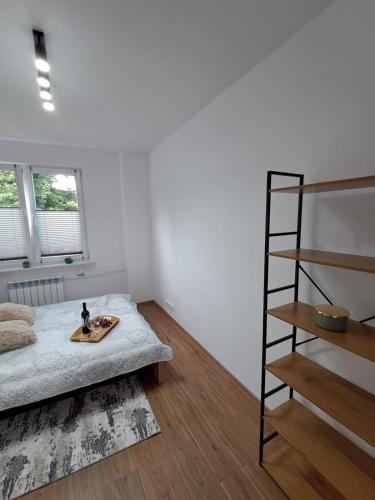 a bedroom with a bed and a book shelf at Apartament przy stawach in Grodzisk Mazowiecki