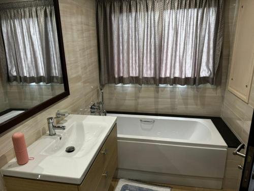 a bathroom with a tub and a sink and a mirror at 300 Rentals in Dar es Salaam