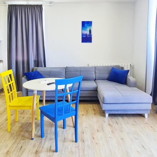 a living room with a couch and a table and chairs at Panoramic Cozy Luxury Apt#15 Sea and Mountain Views Washing machine Bidet Wifi in Batumi