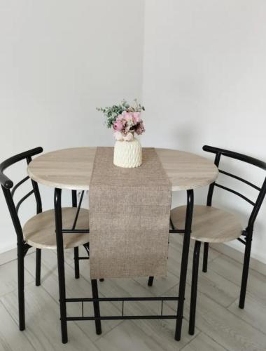 une table en bois avec des chaises et un vase avec des fleurs dans l'établissement Chambre d'amour, à Villeneuve-lès-Avignon