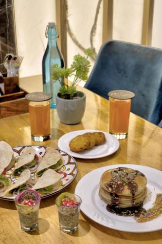 a table with plates of food and glasses of beer at Hotel Gold Souk - Karol Bagh in New Delhi