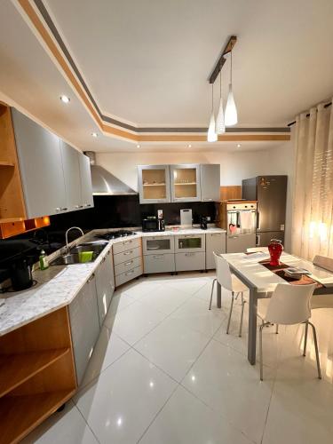 a kitchen with white cabinets and a table and chairs at Casa Gena in Favaro Veneto
