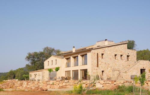an old stone house with a stone wall at Torres De Selma - Eco Resort in El Pla de Manlleu