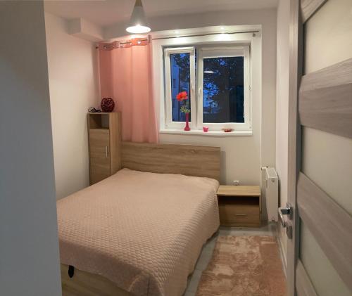 ein kleines Schlafzimmer mit einem Bett und einem Fenster in der Unterkunft Popiel in Toruń