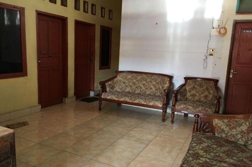 two chairs sitting in a room with a wall at Hotel O Anda Kost 2 Near Lapangan Syech Yusuf Discovery in Sungguminasa