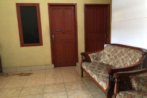 a living room with two chairs and two doors at Hotel O Anda Kost 2 Near Lapangan Syech Yusuf Discovery in Sungguminasa