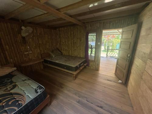 a room with two beds in a room with a door at Moile Moile Surfcamp in Masokut