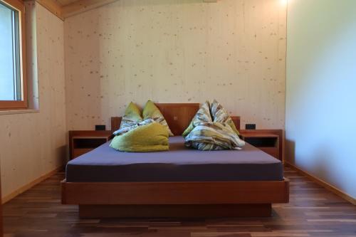 a bed with pillows on it in a room at Rumwaldhof - Wohnung Enzian in Solda