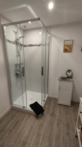 une salle de bain avec douche avec une horloge au mur dans l'établissement jolie maisonnette proche plage et activités nautiques, à Ploudalmézeau