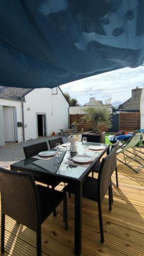 une table et des chaises noires sur une terrasse avec une table et des chaises dans l'établissement jolie maisonnette proche plage et activités nautiques, à Ploudalmézeau
