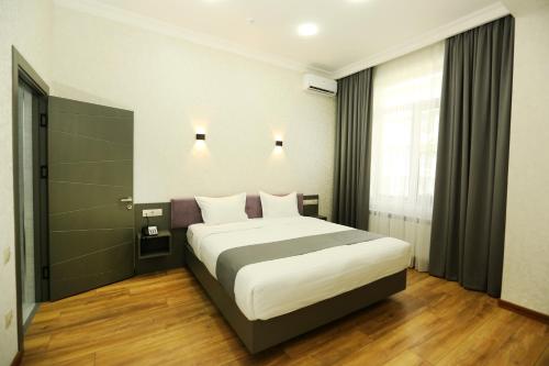 a bedroom with a large bed in a room at Parklane Hotel in Tashkent