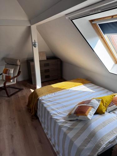 - une chambre mansardée avec une fenêtre dans l'établissement Au pieds du vignoble Colmarien, à Ingersheim