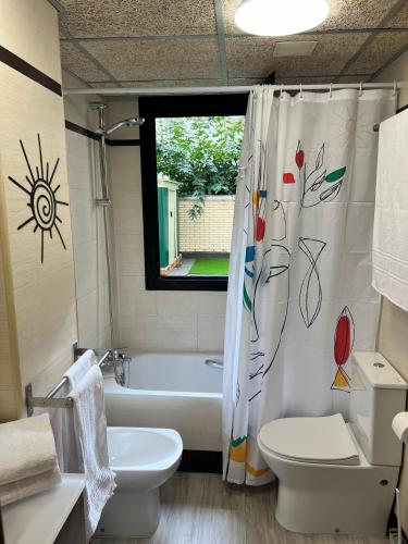 a bathroom with a tub and a toilet and a shower curtain at El BC Zaragoza - Aljafería in Zaragoza